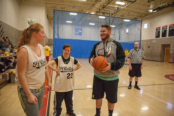 basketball coach speaking with two players on the court