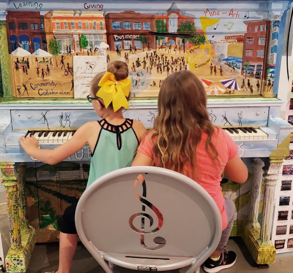children play a painted piano
