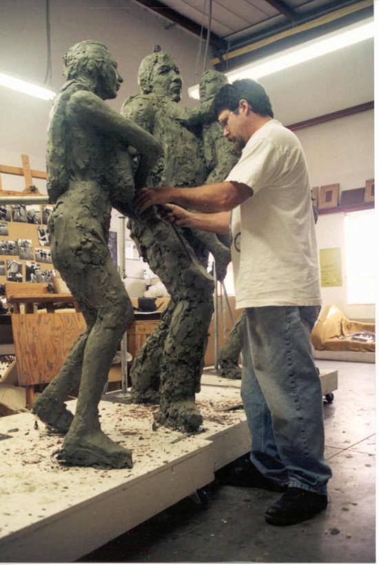 The artist working in his studio on the sculpture