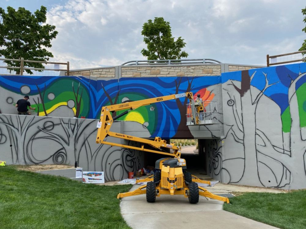 Artist Kristen Vohs paints high areas with a lift