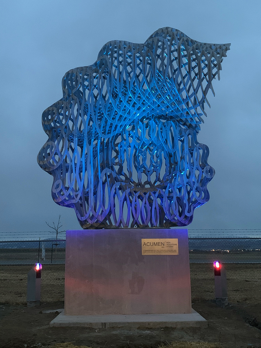 the sculpture lit blue at night