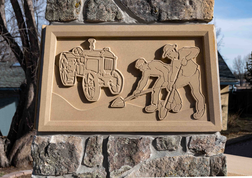 Detail of a concrete art panel showing early agriculture in the area