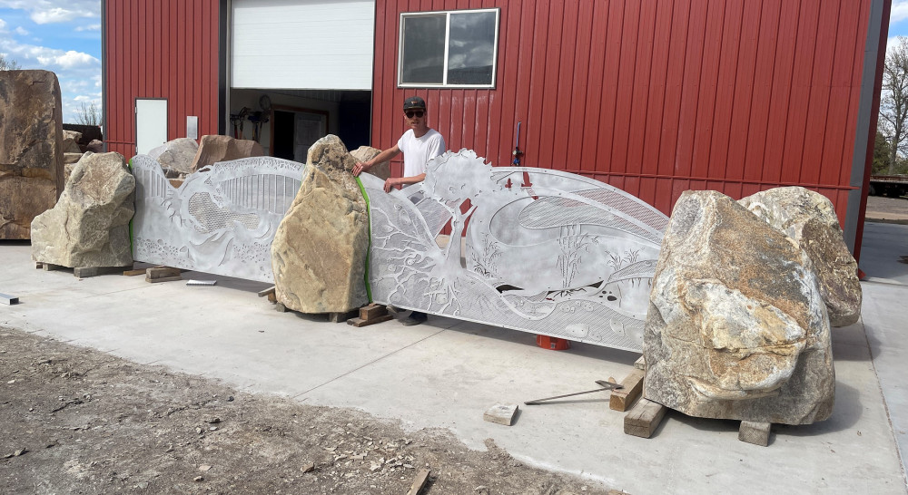 cut metal artwork panels between three stones