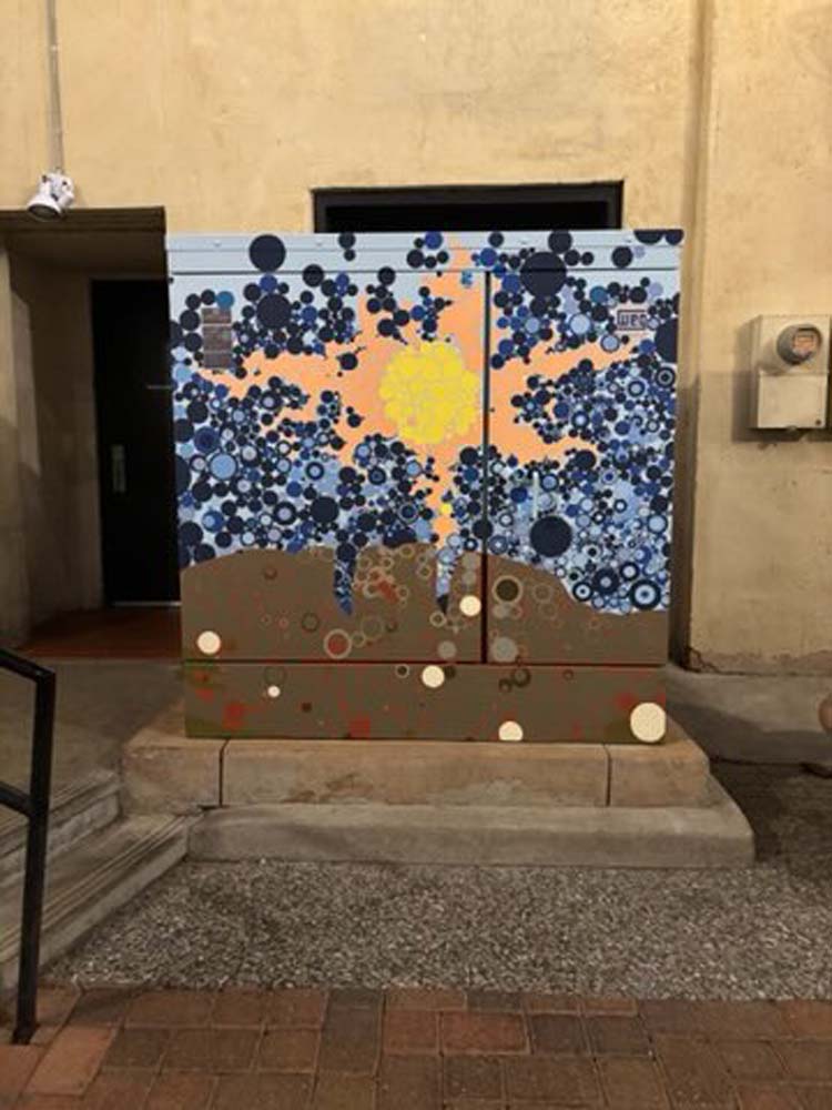 cabinet mural in progress with tan wall with doorways in background