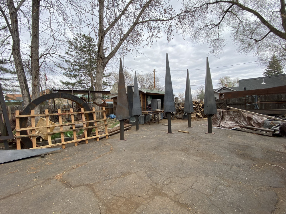 metal trees in a yard with other sculptures