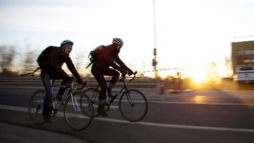 Two cyclists riding their bikes in the winter