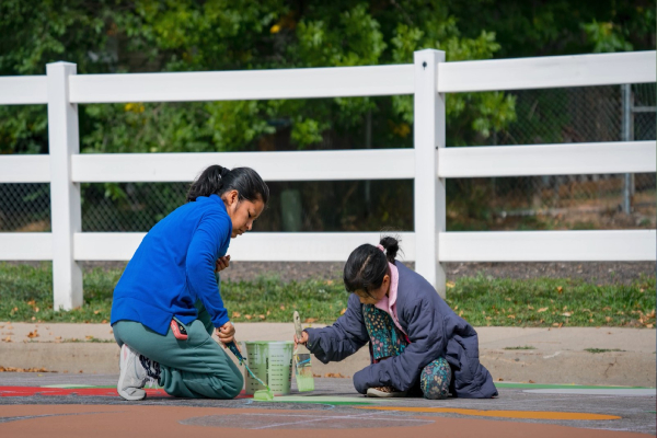 Two people paint on the street