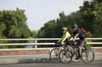 Two cyclists riding side by side