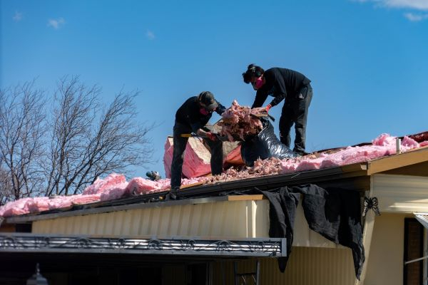 Two men repairing a roof on a manufactured home