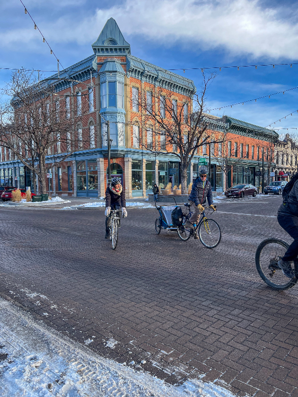 People riding bikes with a historic building in the background