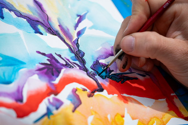 Ryan Stover creates art at University MAX station during Art at the Stops transit-oriented pop-up series in May 2024.
