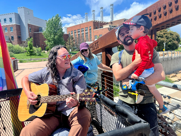Local musician Bevin Luna performs for community members at the Poudre Whitewater Park.