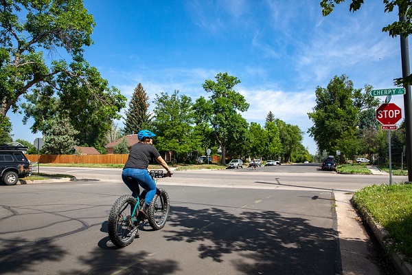 Bicyclist approaching stop sign at a four way intersection.