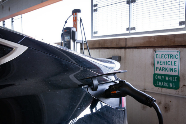 Black electric vehicle charging in a parking garage