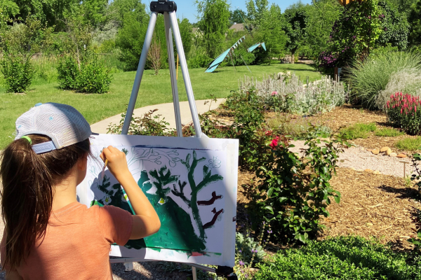 young boys painting on easels in the garden