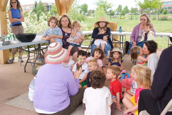 teacher reading to toddlers and parents outside
