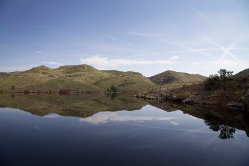 Looking at the surface of the water at Halligan Reservoir with mountains in the background.