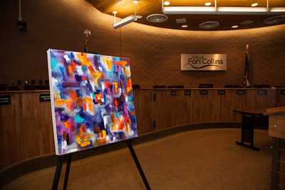 Colorful artwork used as for the 2023 Human Relations Award sitting on a stand in the City of Fort Collins City Hall.