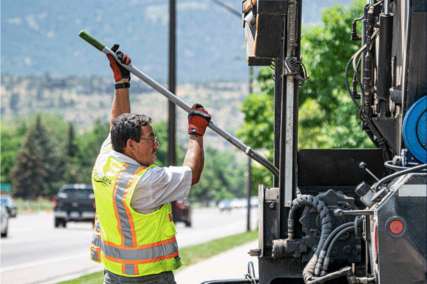 a city employee works with asphalt to fix streets