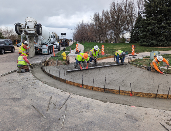 City crews work on installing a sidewalk curb cut