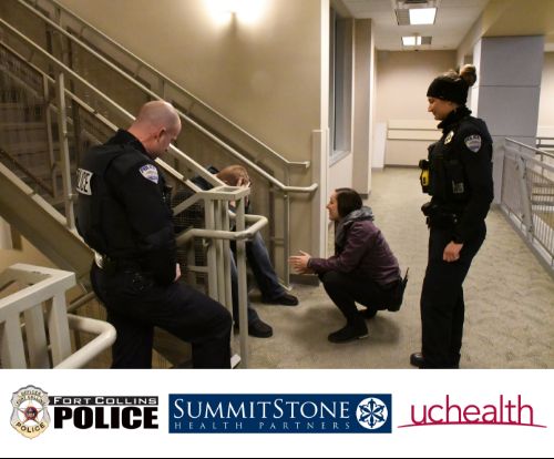 Three people kneeling down talking to a distressed person on a stairway.