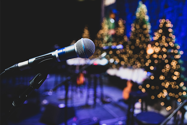 Mic on stage with christmas trees.