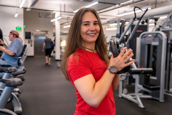Kristin Hertz posing with a kettlebell in a weight room