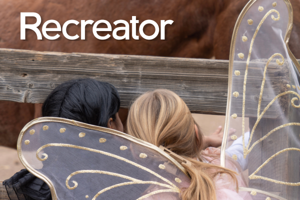 Two girls dressed in costumes at the Farm with the overlaid text "Recreator"