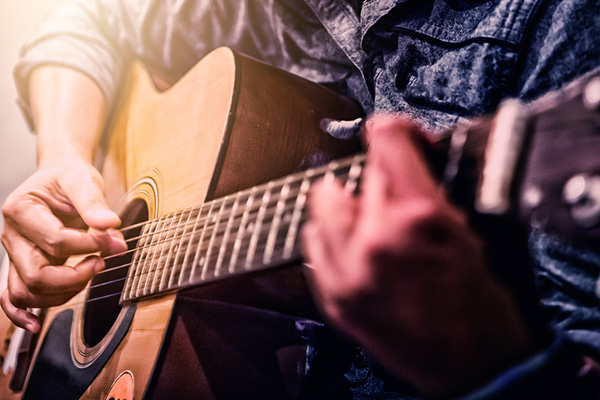 close up of someone playing guitar
