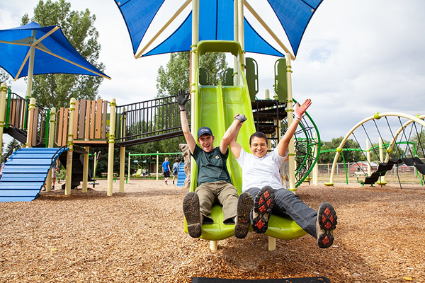 parks workers smiling and sliding down slides