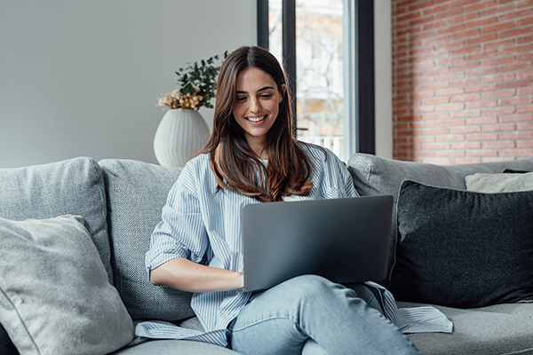 woman holding laptop and smiling