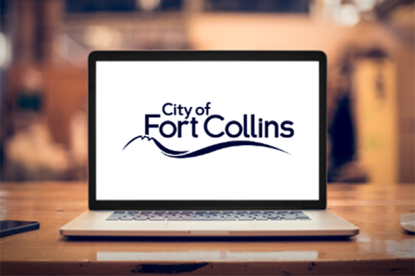 A photo illustration of a laptop with the City of Fort Collins logo on its screen.