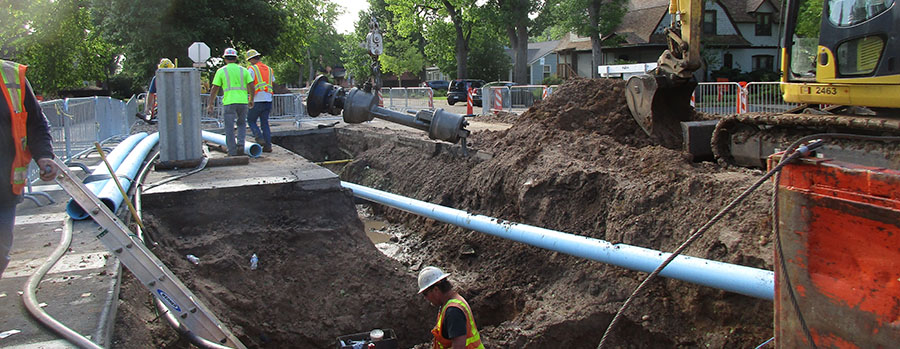 Image of pipe construction in the street with large equipment