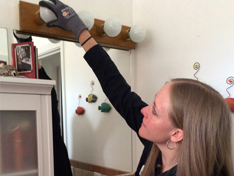 woman replacing lightbulbs