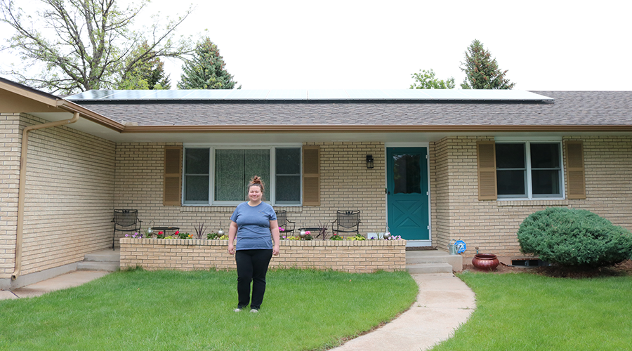 Person with rooftop solar in front of their home.