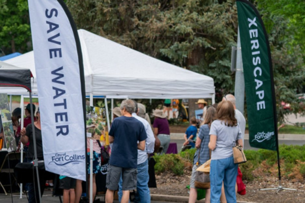 A water conservation tent with 'save water' and 'xeriscape' banners