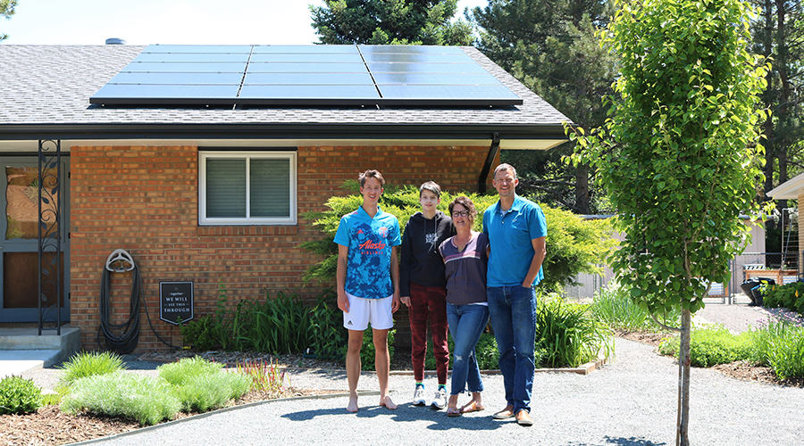 Family with rooftop solar in front of their home