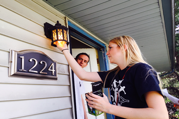 Volunteer installing porch lightbulb