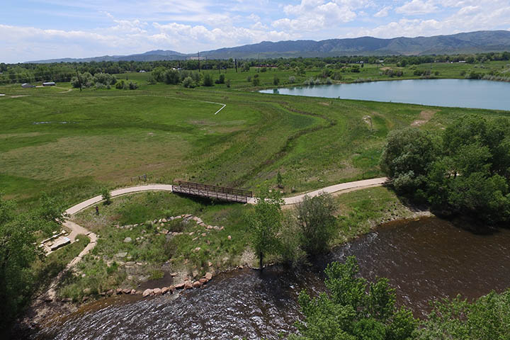 View looking south at the lower West Vine Outfall Channel as it meets the Poudre River.