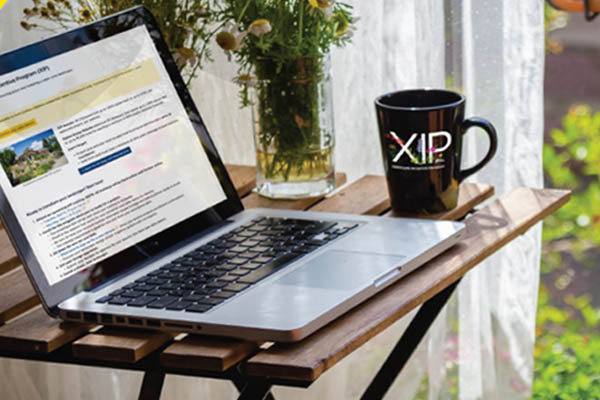 laptop open with coffee cup nearby