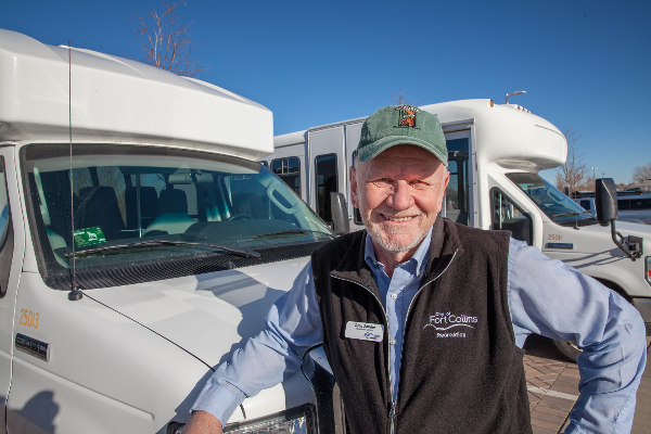 Volunteer driver stands in front of bus