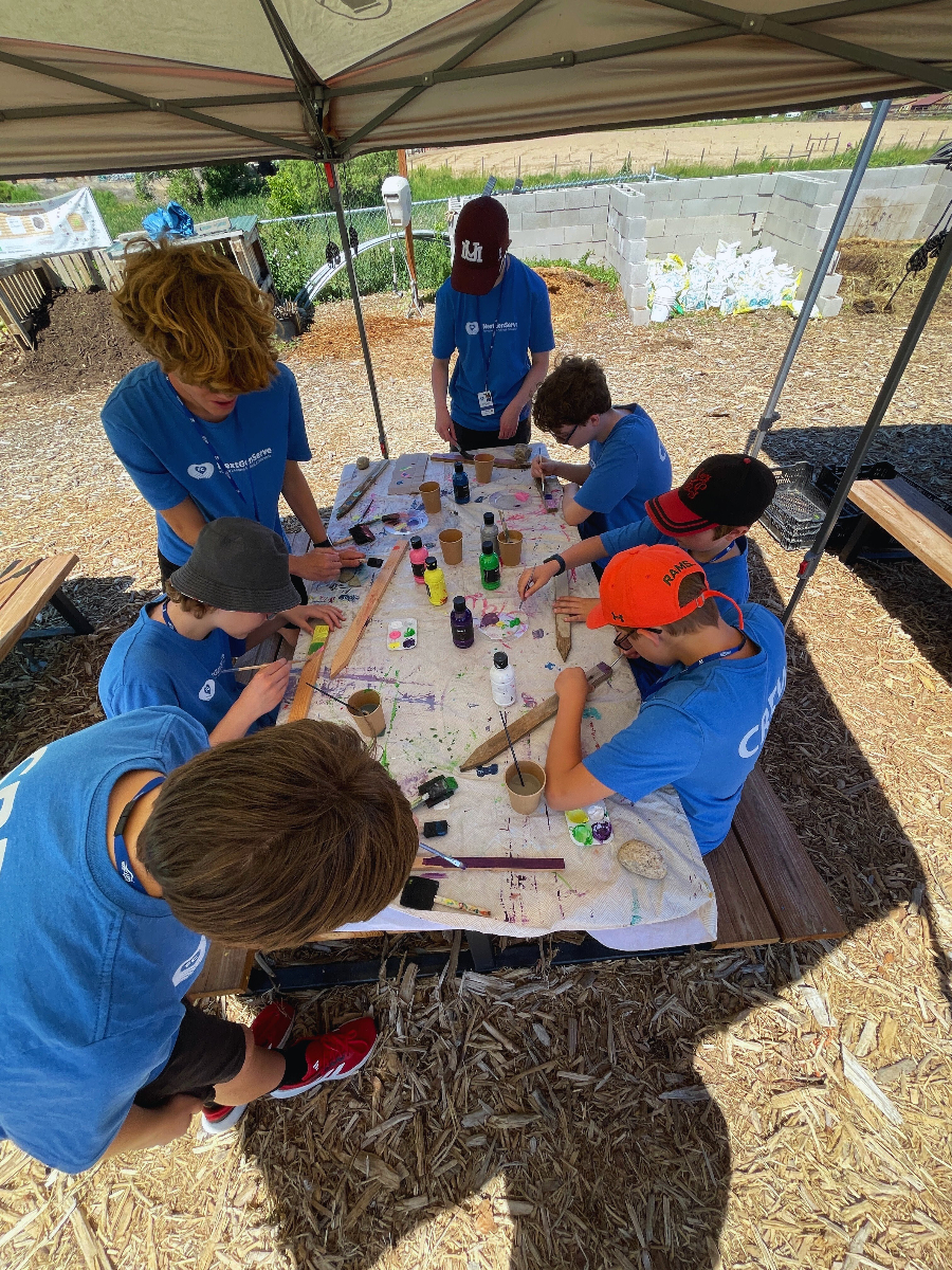 Group of teens painting stakes.