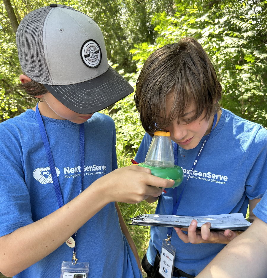 Teens looking at the macroinvertebrates at the Poudre River.