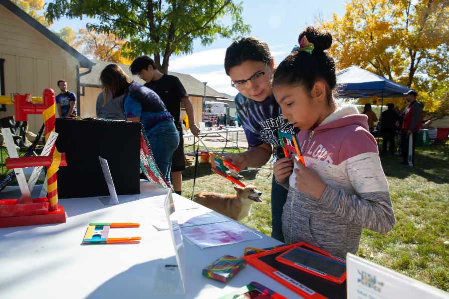 Volunteer helping kiddo during a Neighborhood Services event