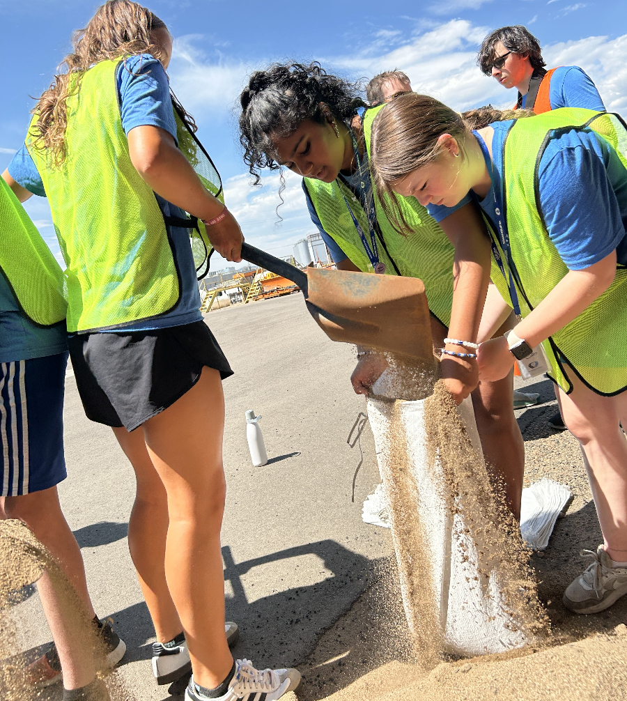 Teens filling a sandbag
