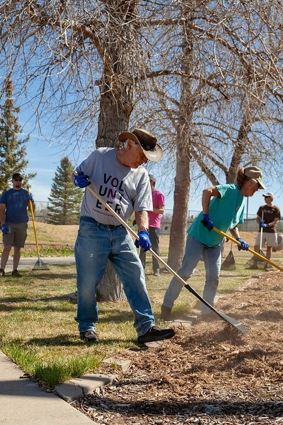 volunteers raking leaves in community park